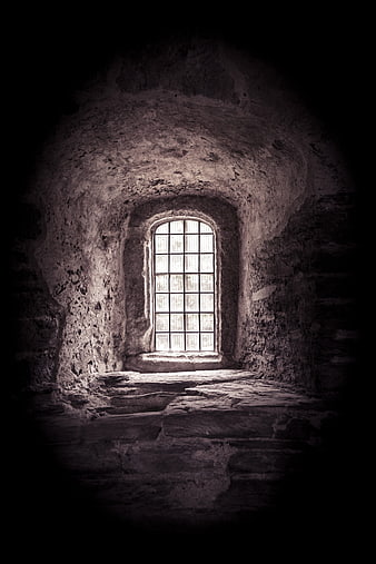 Dark medieval stone room with arched window