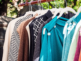 Colorful Knit Sweaters Hanging on Outdoor Clothes Rack