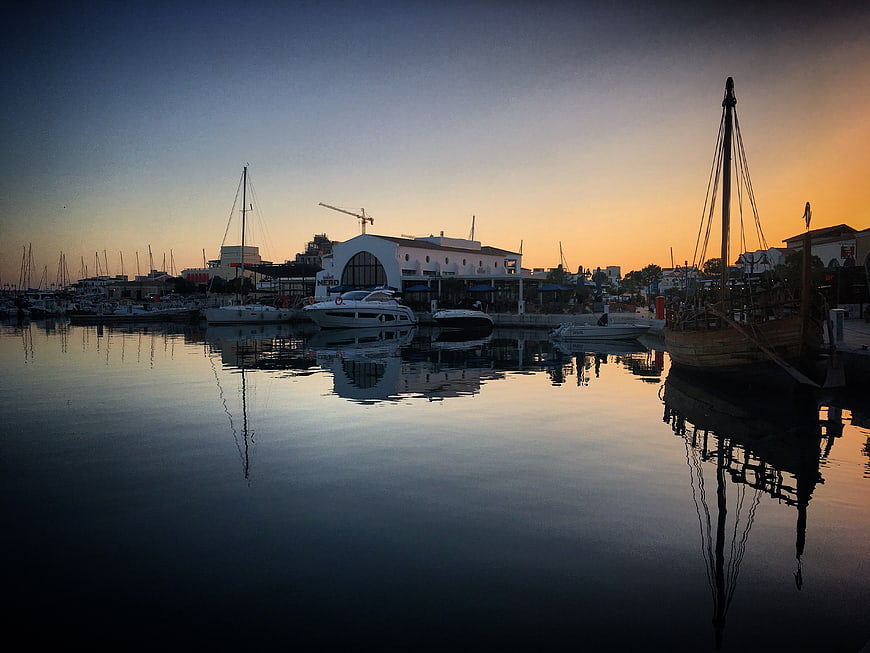 Serene Harbor Sunset with Boat Reflections and Marina Skyline