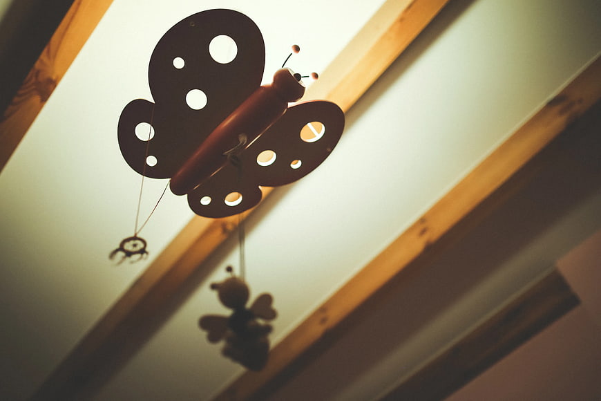 Silhouette of wooden butterfly mobile hanging from ceiling