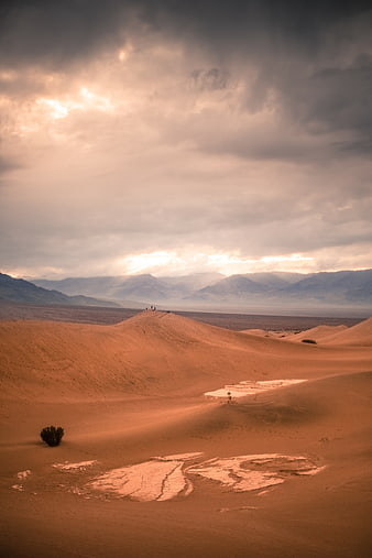 Dramatic desert landscape with sand dunes and mountains