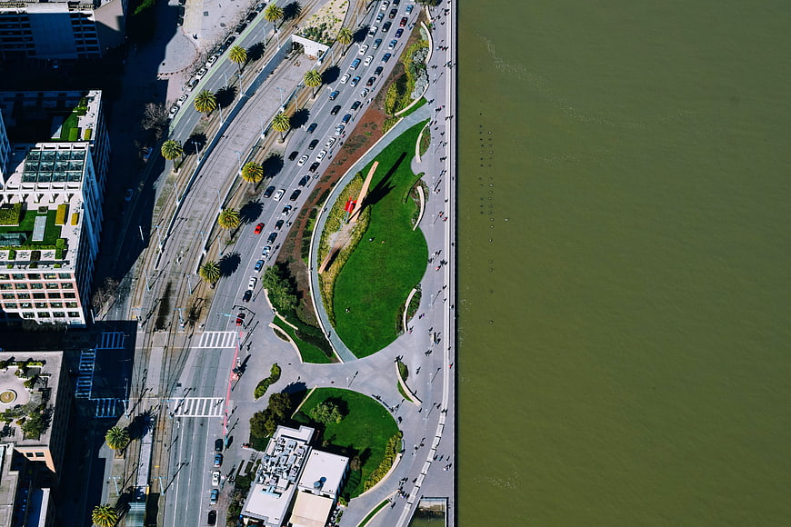 Aerial view of urban waterfront park and busy highway