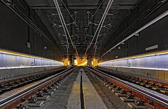 Symmetrical view of empty railway tracks inside a modern concrete tunnel
