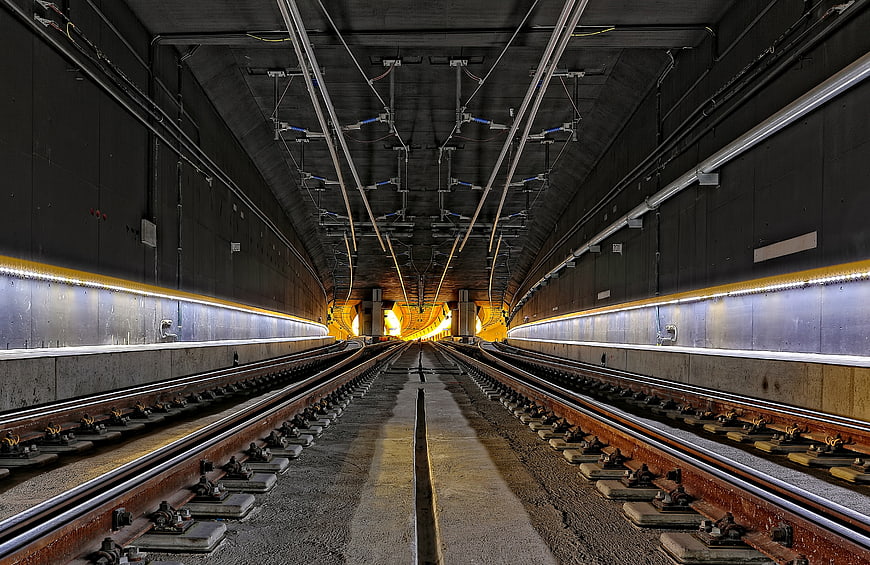 Symmetrical view of empty railway tracks inside a modern concrete tunnel