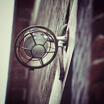 Vintage industrial security light fixture on brick wall