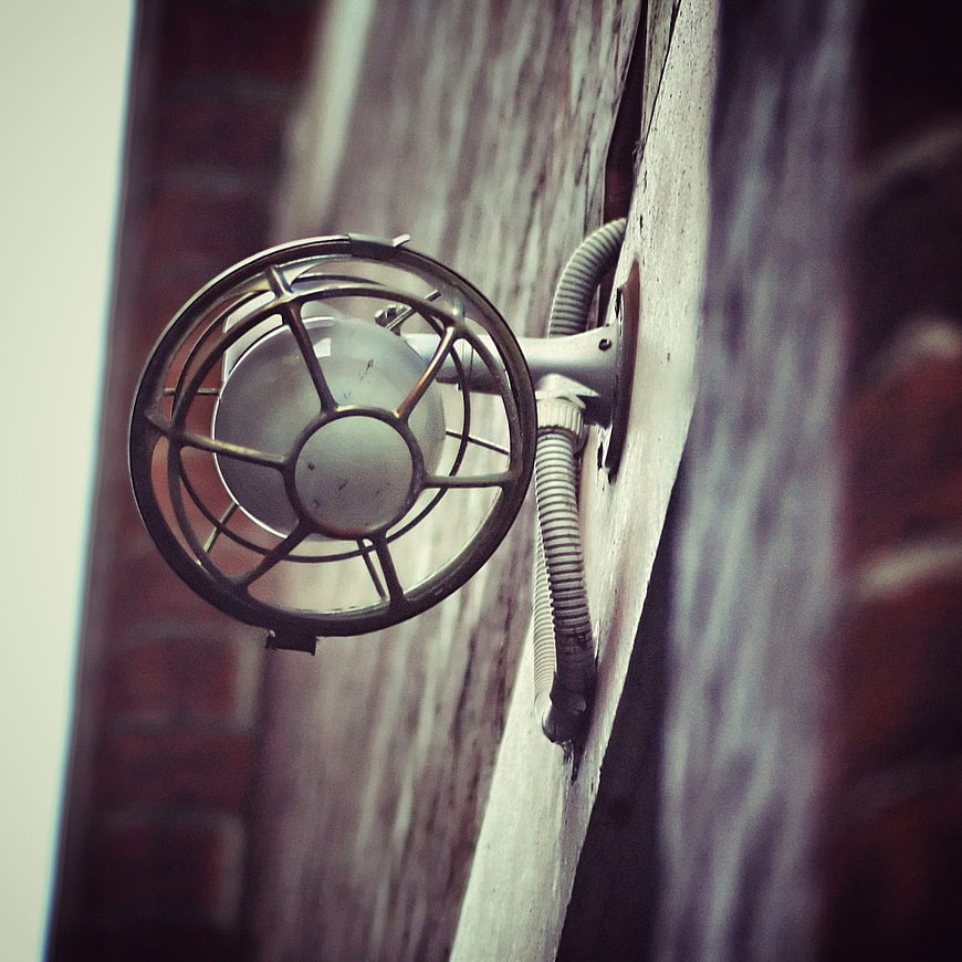 Vintage industrial security light fixture on brick wall