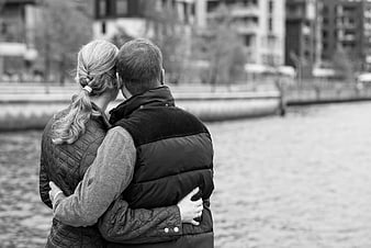 Couple embracing by river in black and white