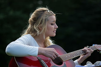 Blonde Woman Playing Red Acoustic Guitar Outdoors