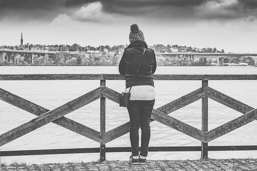 Woman in Beanie Looking at River Cityscape Black and White