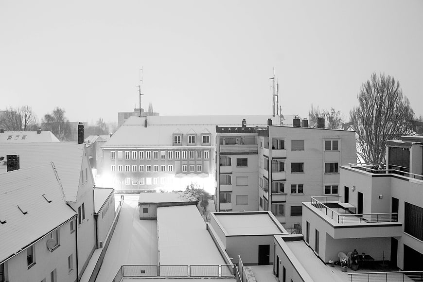 Black and white winter cityscape with snow-covered rooftops