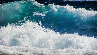 Powerful turquoise ocean wave crashing with white foam