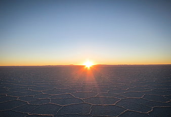 Sunrise over the hexagonal patterns of the Uyuni Salt Flats in Bolivia