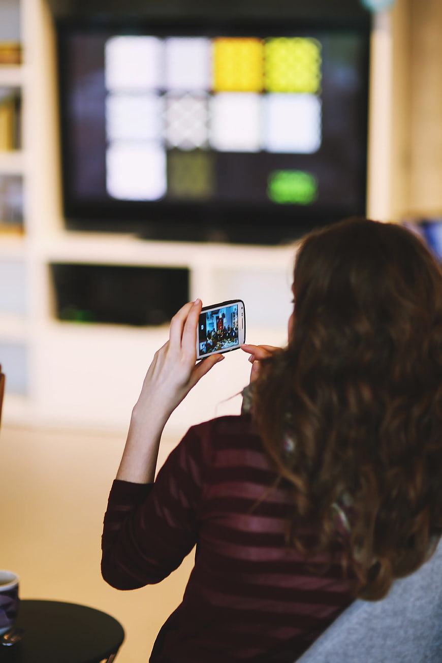 Woman taking photo with smartphone at home