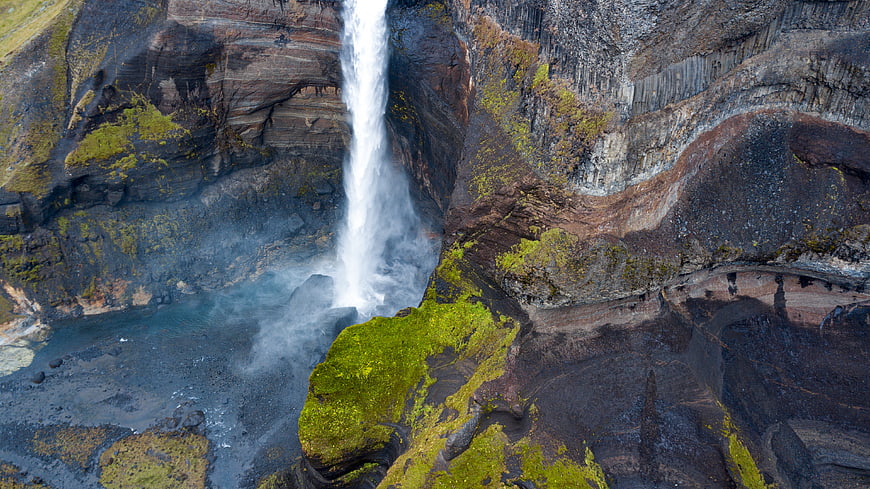 Aerial View of Waterfall Cascading into Turquoise Pool in Iceland