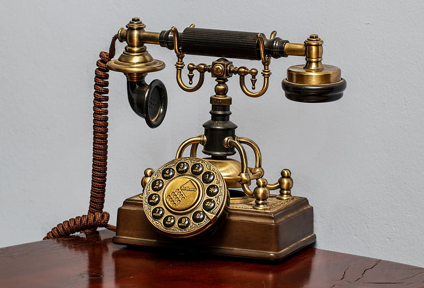 Vintage Brass Rotary Telephone On Wooden Table