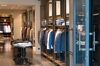 Interior of a modern men's clothing store with racks of shirts and jackets