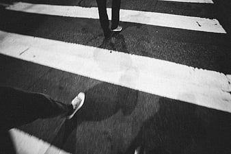 Black and white feet walking on zebra crossing at night