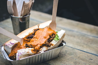 Pulled pork sandwich with spicy sauce on wooden table