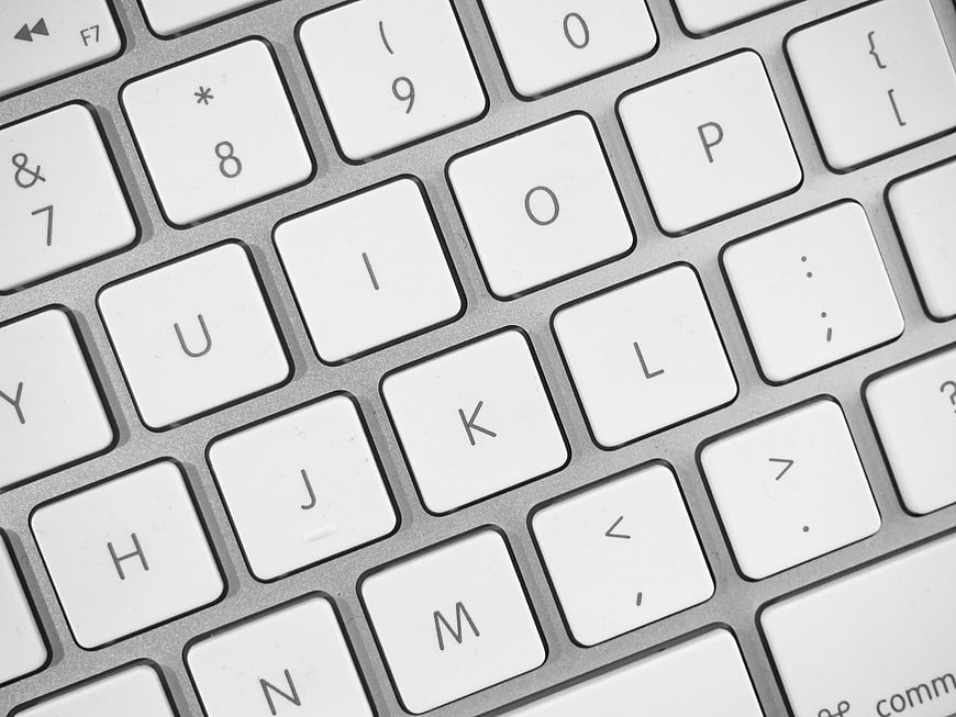 Close-up of white computer keyboard keys on silver background
