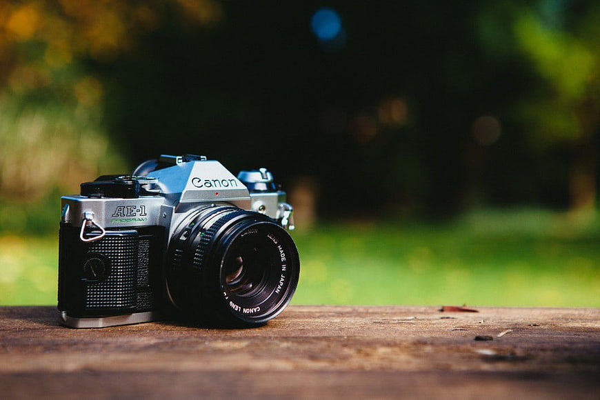 Vintage Canon AE-1 Camera on Wooden Surface Outdoors