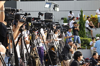 Crowd of journalists and cameras at outdoor press event