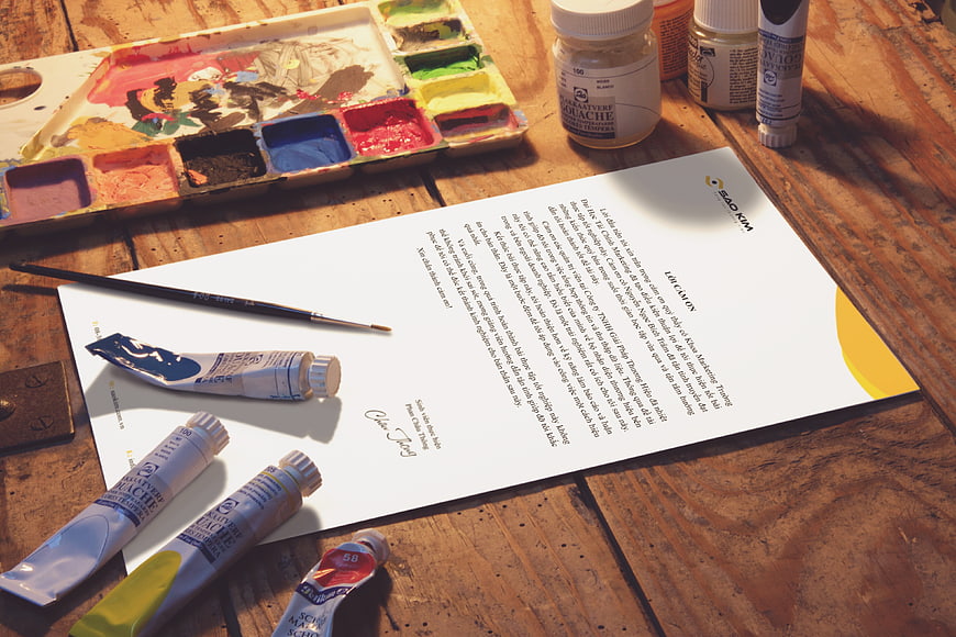 Art supplies and document on rustic wooden table