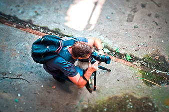 High angle view of photographer kneeling with camera