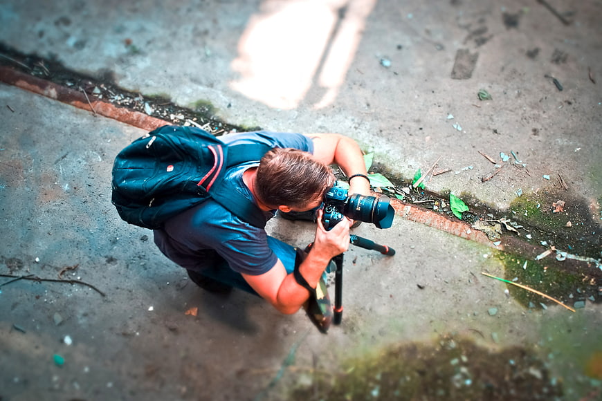 High angle view of photographer kneeling with camera