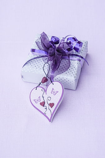 Purple Gift Box With Heart Ornament And Ribbon On White Background