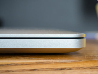 Close-up of silver laptop edge on wooden desk
