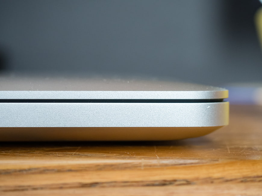 Close-up of silver laptop edge on wooden desk