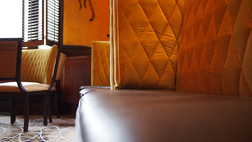 Close-up of yellow tufted booth seating in a restaurant