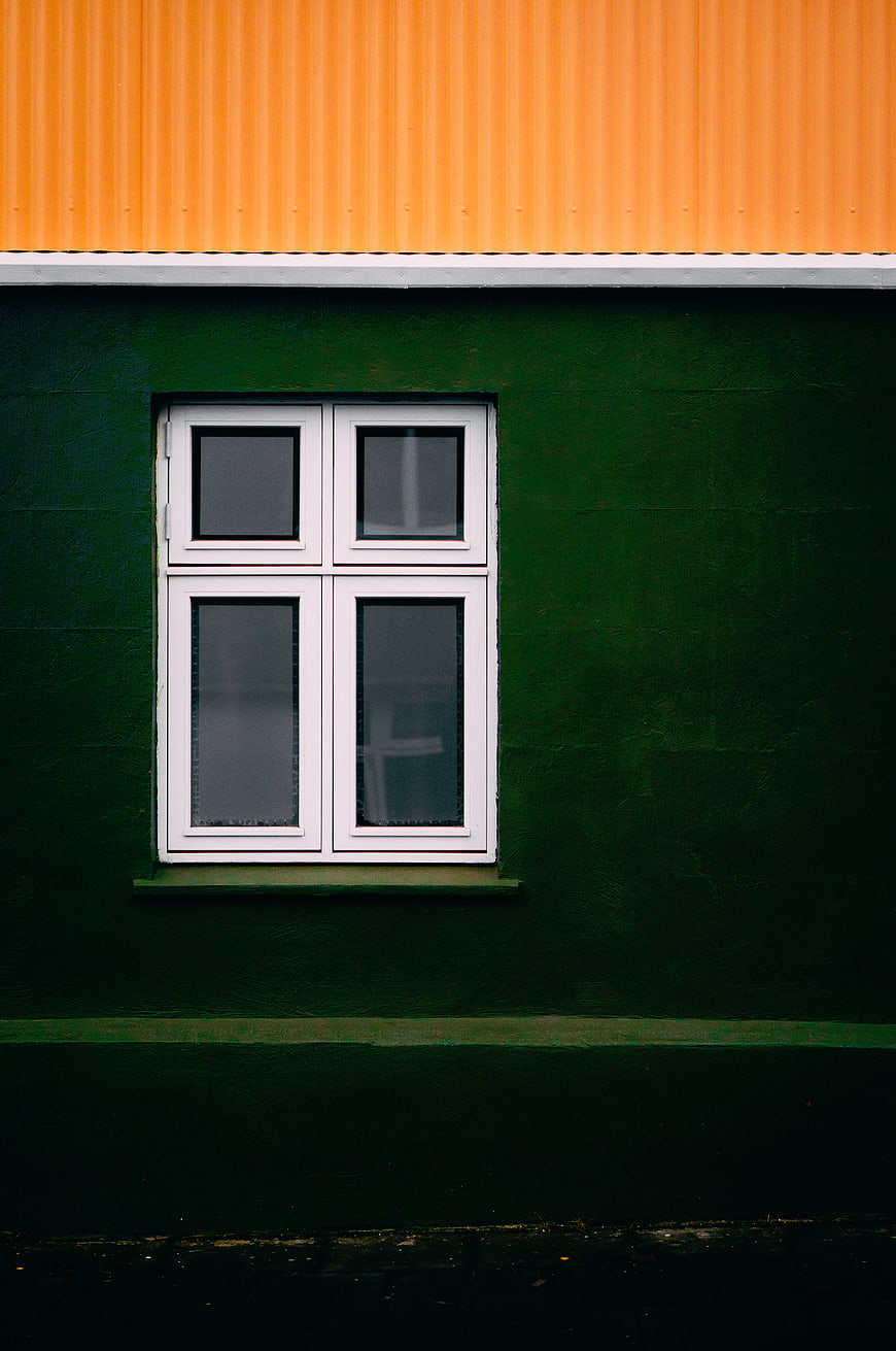 Minimalist Green Wall with White Window and Orange Roof