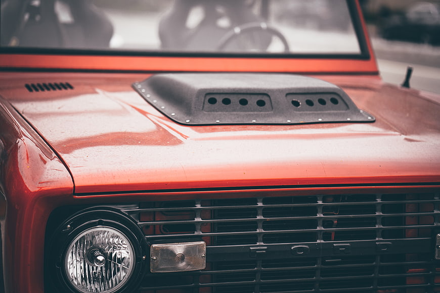 Close-up of vintage red Ford truck hood and grille