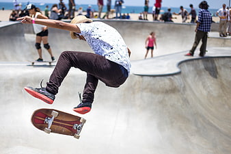 Skateboarder performing mid-air trick at outdoor concrete skate park