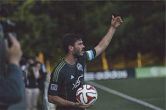 Soccer Player Celebrating with Ball on Field