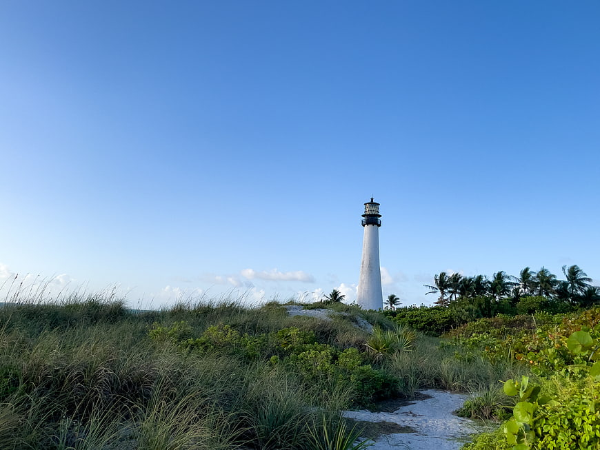 White Lighthouse on Sandy Dunes with Blue Sky