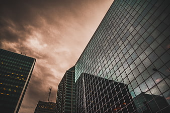 Low angle view of modern glass skyscrapers against dramatic sky