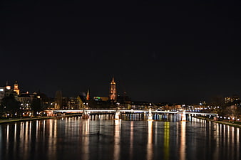 Night view of Frankfurt skyline with bridge and river reflections