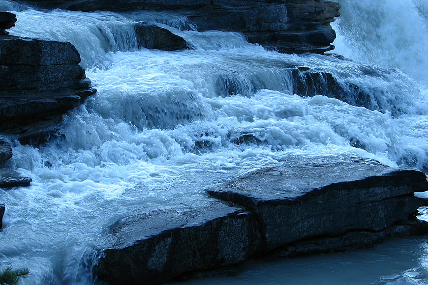 Powerful Blue Waterfall Cascading Over Layered Rocks
