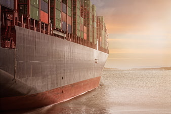 Massive Container Ship Sailing at Sunset