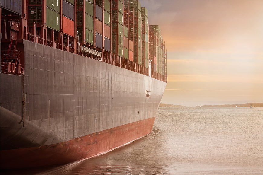 Massive Container Ship Sailing at Sunset