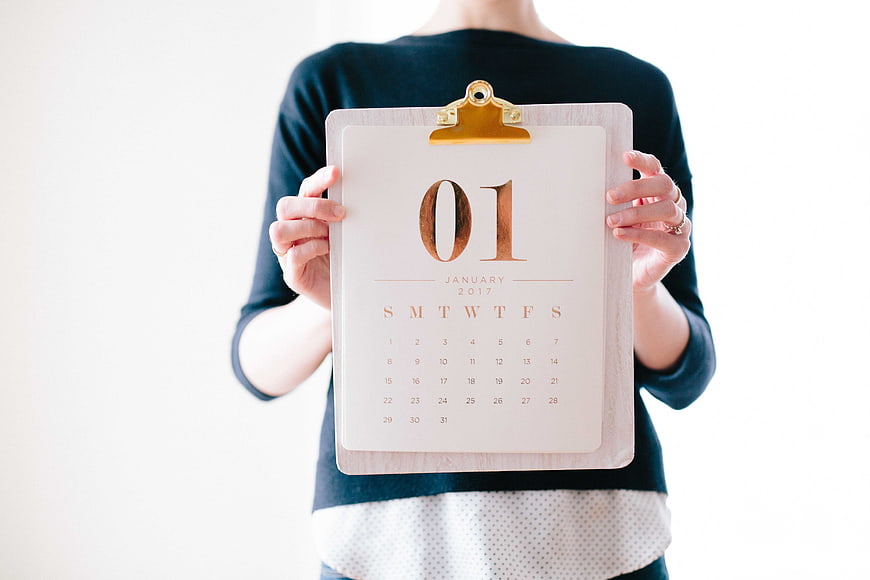 Woman holding clipboard with January 2017 calendar