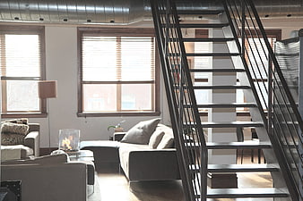 Modern Loft Interior With Metal Staircase And Gray Sofa