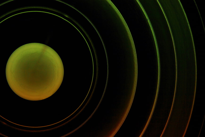 Abstract Green and Orange Concentric Circles on Black Background