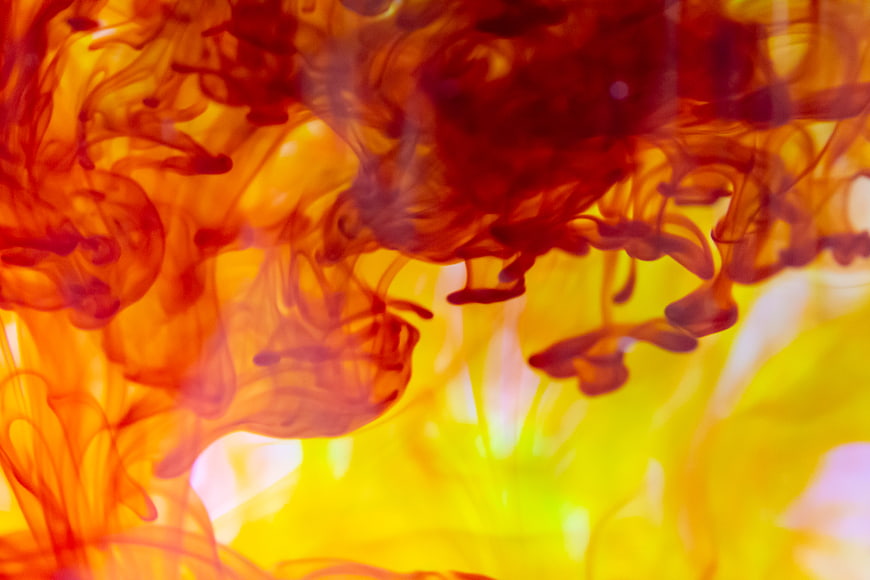 Abstract red and yellow ink swirling in water