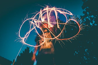 Long Exposure Sparkler Light Painting Against Blue Sky