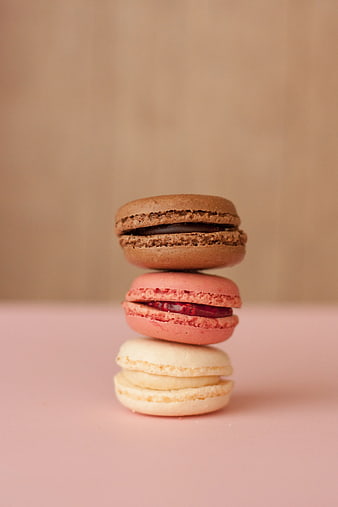 Stack of Three Colorful Macarons on Pink Background