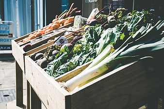 Fresh organic vegetables in wooden crates at outdoor market
