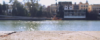 Textured concrete foreground with blurred river and cityscape background
